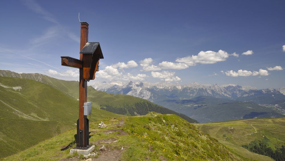 Croix au sommet face aux Alpes — le reseau des Foyers de Charite