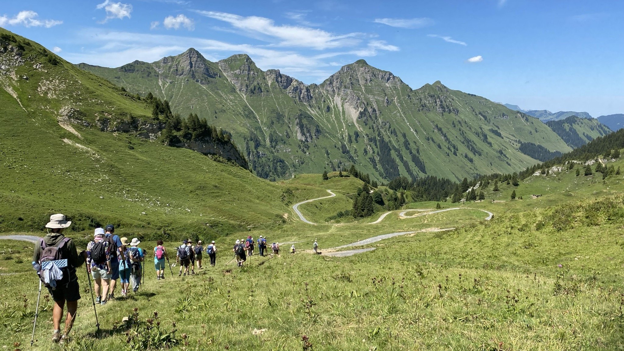 Groupe de retraitants en randonnée sur un alpage alpin, été
